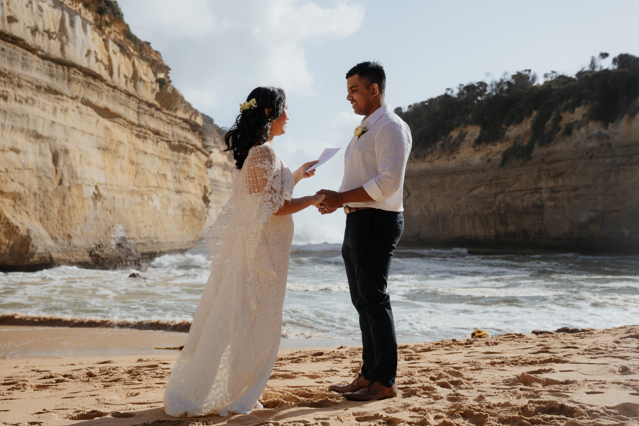 A couple reading vows during their elopement on the beach